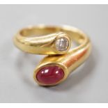 A modern 18k, cabochon ruby and round cut diamond set crossover ring, size N, gross weight 6.8