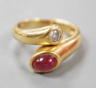 A modern 18k, cabochon ruby and round cut diamond set crossover ring, size N, gross weight 6.8