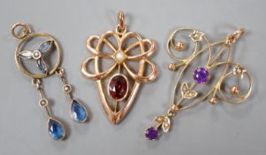 Three assorted early 20th century yellow metal and gem set pendants, including 9ct garnet and