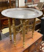 A Benares brass tray top folding table with later gold painted underframe, diameter 61cm