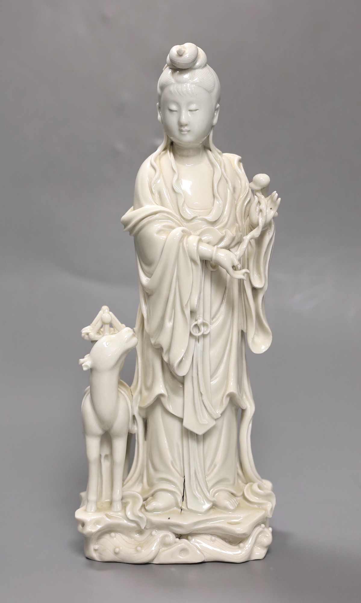 A Chinese Dehua blanc-de chine Guanyin group, late 19th/early 20th century, seal mark to back, 27cm