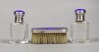 A pair of George V silver and enamel mounted glass scent bottles, 73mm and a small mounted brush,