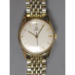 A gentleman's 9ct gold Omega manual wind wrist watch, on an Omega steel and gold plated bracelet,