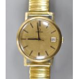 A gentleman's 1960' yellow metal Omega manual wind wrist watch, with date aperture, on associated
