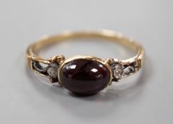 A 19th century yellow metal and single stone cabochon garnet set ring, with diamond chip set