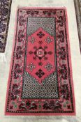 A Turkish red ground multi medallion rug, 137 x 72cm