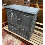 An early 20th century grey painted dentist's cabinet with nine drawers, a slide and two cupboards,