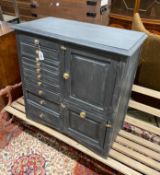 An early 20th century grey painted dentist's cabinet with nine drawers, a slide and two cupboards,