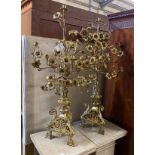 A pair of French gilt brass candelabra with flowering branches and ecclesiastical bases, height