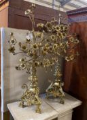 A pair of French gilt brass candelabra with flowering branches and ecclesiastical bases, height