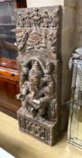 An Indian stained and carved hardwood panel centred with Ganesh, width 54cm, height 160cm