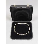 A cased modern 750 yellow metal and Tahitian? pearl set necklace, with diamond chip set clasp, 39cm,
