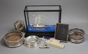A group of silver and white metal items including a cased boat model, cigar cutter and mounted