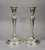 A pair of George V silver candlesticks, with panelled tapering stems, Thomas Bradbury & Sons,
