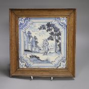 A large Delft blue and white ‘figure in a landscape’ tile, 18th century, framed, 20cm sq excl frame