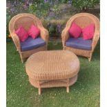 A pair of rattan conservatory chairs and a matching low table