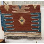 A Kilim runner with geometric motifs on a brick red ground, 384 x 85cm