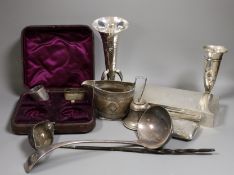A mixed collection of small silver items to include a cigarette box, a posy vase, condiments, napkin
