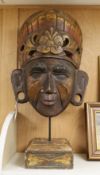 A large Asian carved wood mask on stand 66cm