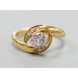 A continental yellow metal and single stone diamond set ring, with diamond set crossover