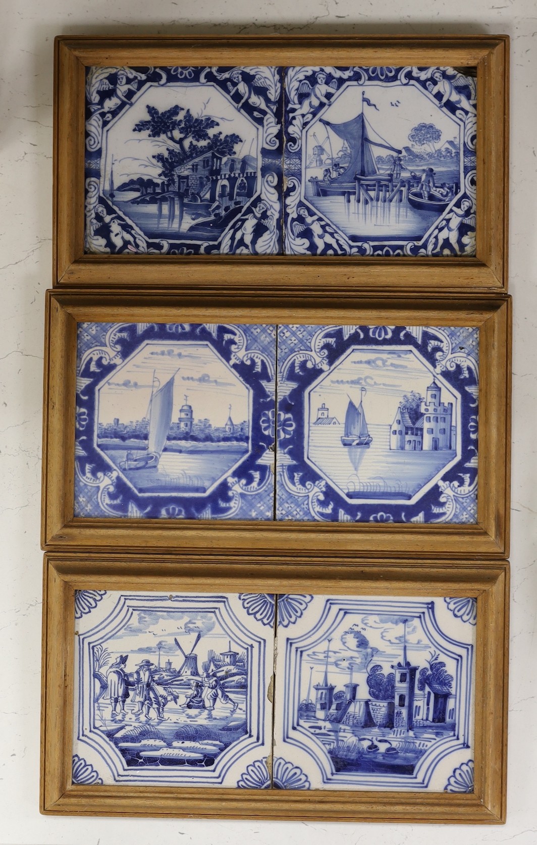 Three pairs of Delft blue and white ‘landscape’ tiles, 18th/19th century, in double frames