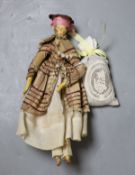 An early 19th century peg doll, wearing contemporary costume, 25.5 cm long