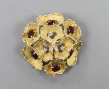 A 1960's textured 18ct gold, garnet and diamond cluster set open work flower head brooch, maker C.