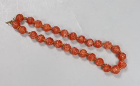 A Chinese chalcedony bead necklace, carved with medallion motifs, early 20th century