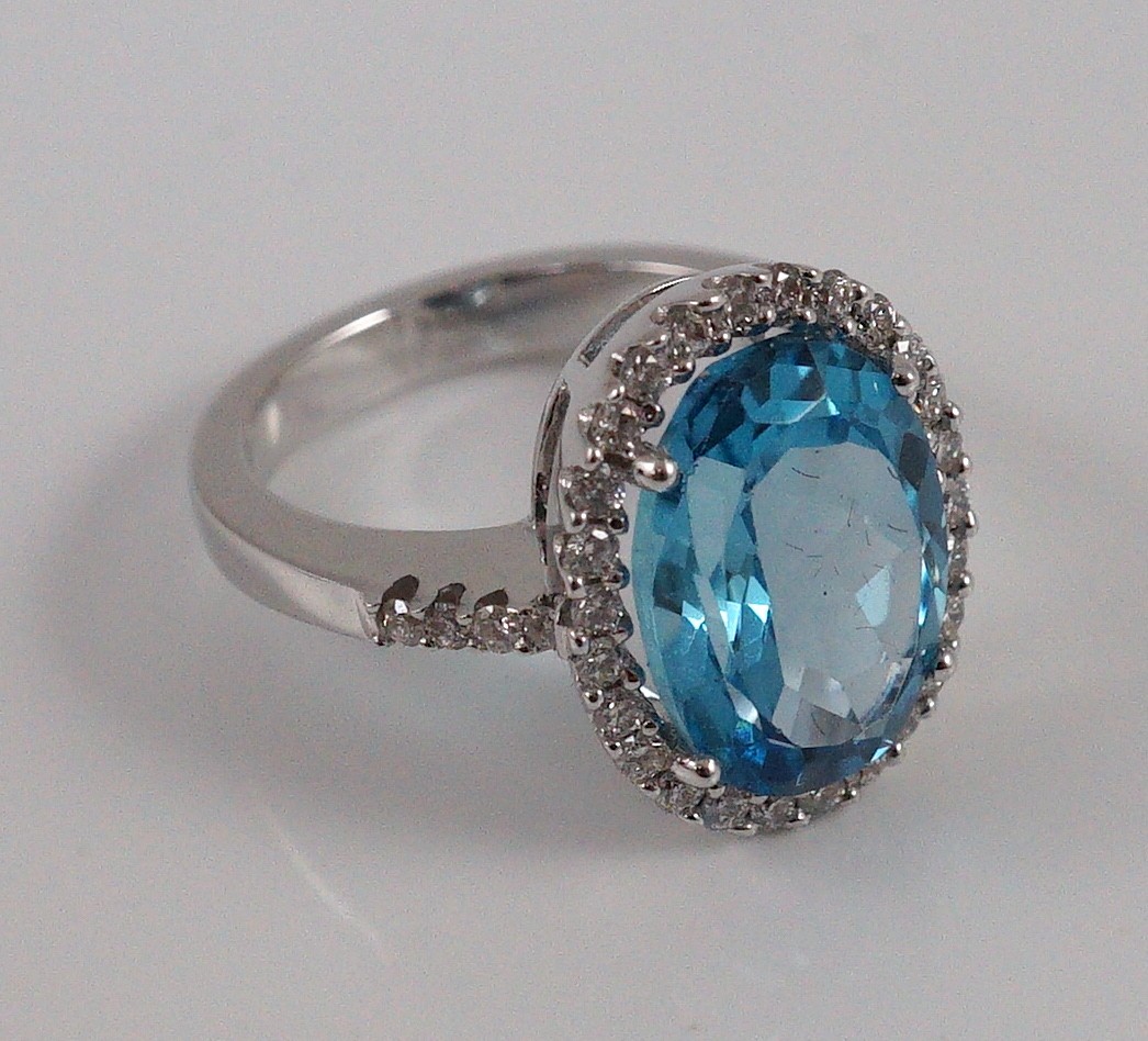 A modern 18k white gold, blue topaz and diamond oval cluster dress ring, with diamond set shoulders, - Image 5 of 5