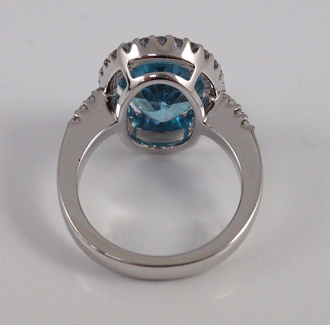 A modern 18k white gold, blue topaz and diamond oval cluster dress ring, with diamond set shoulders, - Image 4 of 5