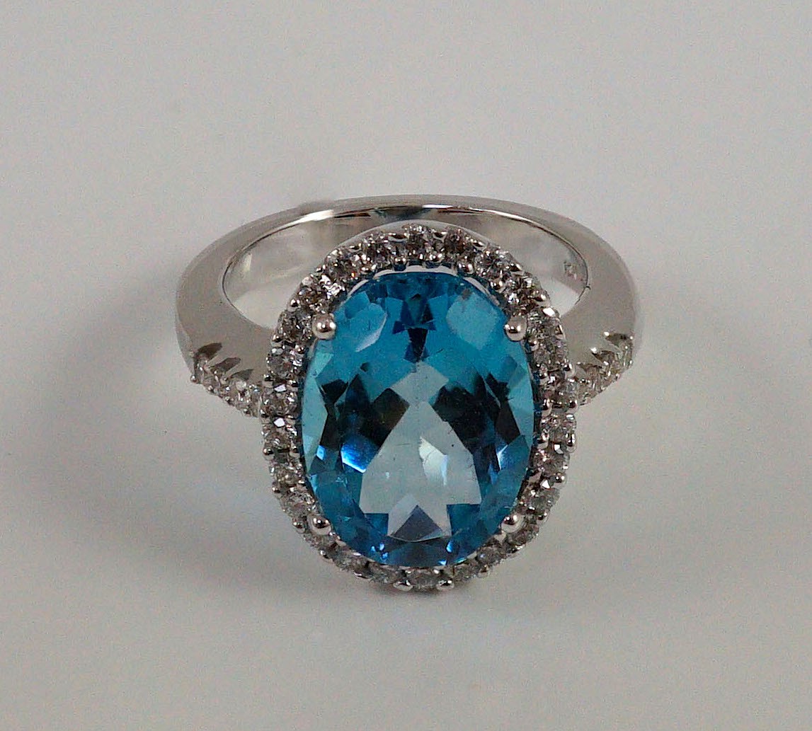 A modern 18k white gold, blue topaz and diamond oval cluster dress ring, with diamond set shoulders, - Image 2 of 5