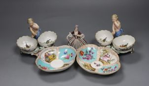 Two Berlin figural salts, 13cm high together with two Dresden saucers and a continental figurine