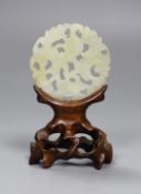 A Chinese jade disc and wood stand,9cms high,