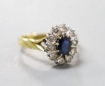 A modern 18ct gold, sapphire and diamond set oval cluster ring, size L, gross weight 4.6 grams.