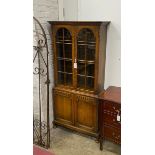 A 1920's glazed oak two door glazed cabinet, width 80cm, depth 30cm, height 175cm