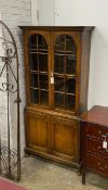 A 1920's glazed oak two door glazed cabinet, width 80cm, depth 30cm, height 175cm