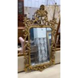 An 18th century style carved giltwood scrollwork mirror, width 64cm, height 132cm