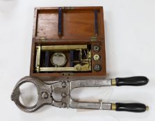A mahogany cased microscope and a pair of Burdizzo tail dockers,40cms long,