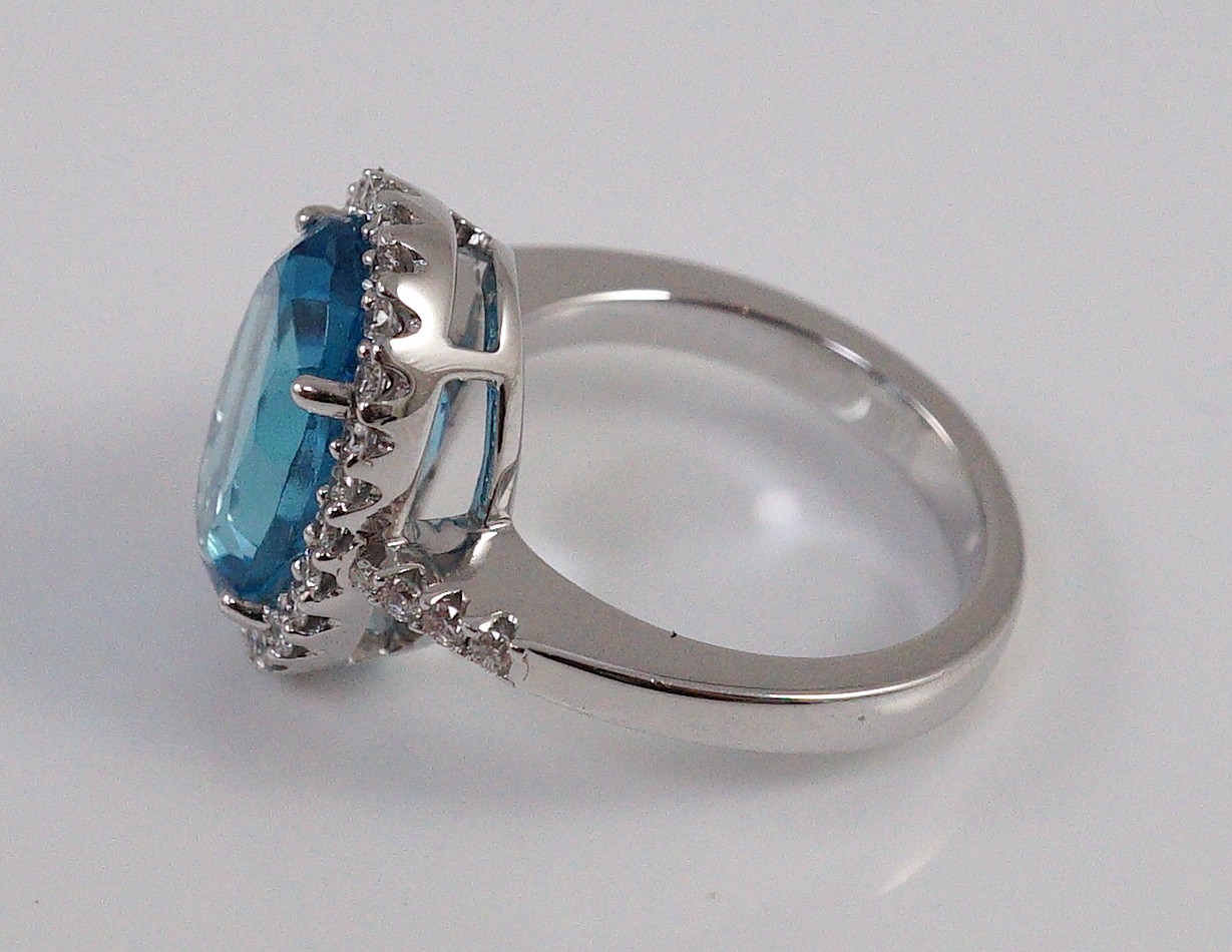 A modern 18k white gold, blue topaz and diamond oval cluster dress ring, with diamond set shoulders, - Image 3 of 5