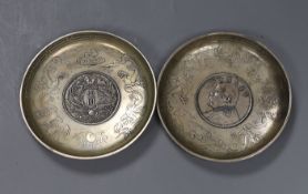 A pair of Chinese coin inserted dishes, 9cms diameter,