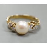 A 14kt yellow metal and single stone cultured pearl ring, with diamond set shoulders, size J,