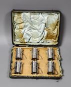 A cased set of six Edwardian reeded silver tot mugs, Harrods Stores Ltd?, London, 1908, 44mm.