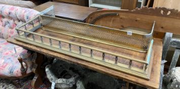 An Edwardian balustraded brass fender, width 134cm and a similar pierced brass fire kerb, width