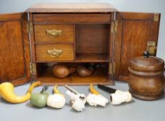 A carved smoker’s cabinet containing Meerschaum and other pipes and a tobacco jar,cabinet 25cm high