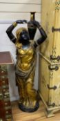 A pair of large gilded and brown patinated bronze figures of Nubian women holding amphoras, height