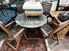 A circular weathered teak folding garden table and four teak folding armchairs, stamped Royal Craft,