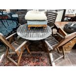 A circular weathered teak folding garden table and four teak folding armchairs, stamped Royal Craft,