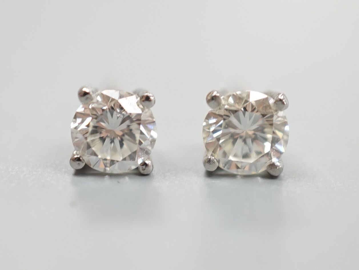 A modern pair of platinum and solitaire diamond set ear studs, total carat weight approx. 0.86ct.