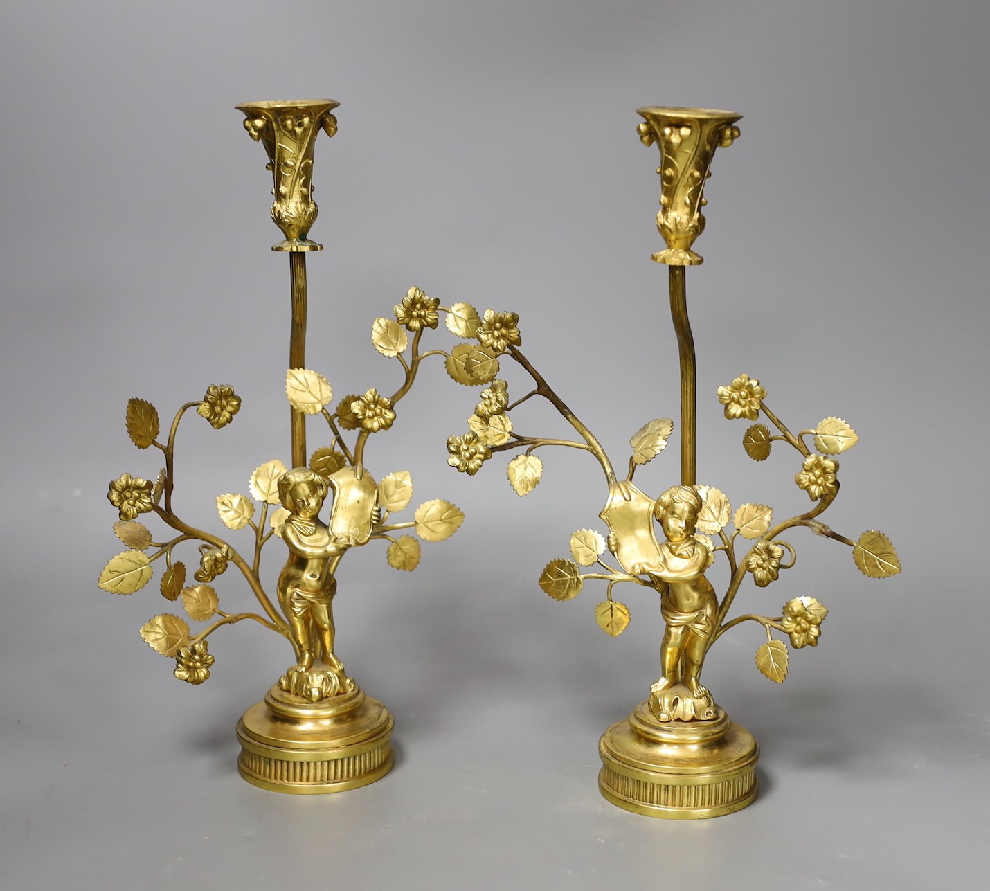 A pair of figural gilt metal candlesticks (Birmingham 1902 by Elkington & Company and Chester