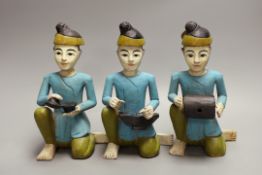 Three Malaysian painted wooden musican figures, 24cm tall